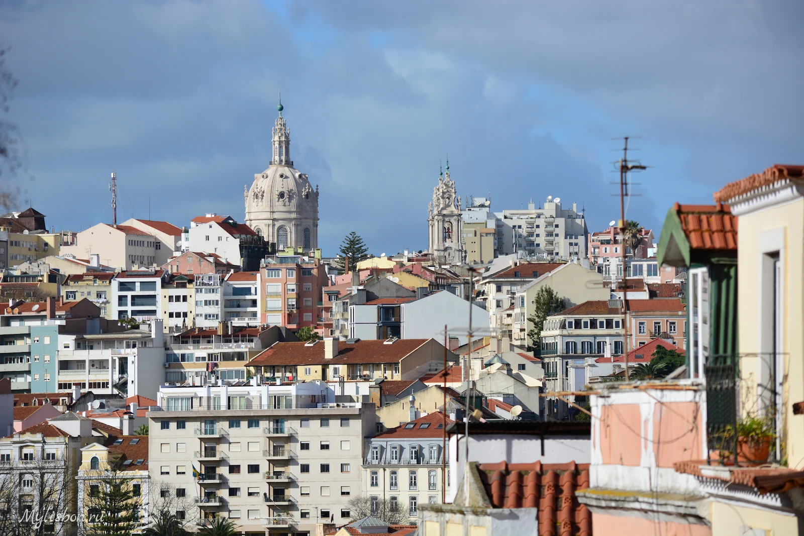 Telhados de Lisboa e a cúpula da Basílica da Estrela sob um céu de nuvens